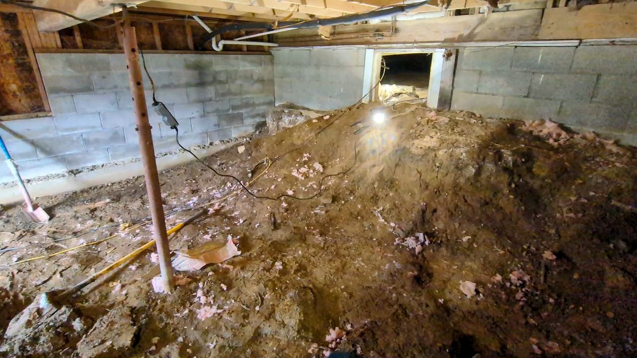 A dug-out crawl space under a Louisville house, daylight coming in through the access opening
