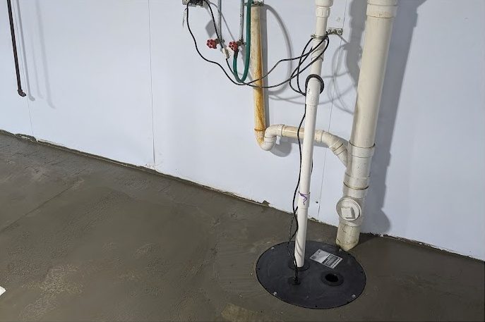 After: the same corner with a lined wall, sealed sump lid and discharge pipe