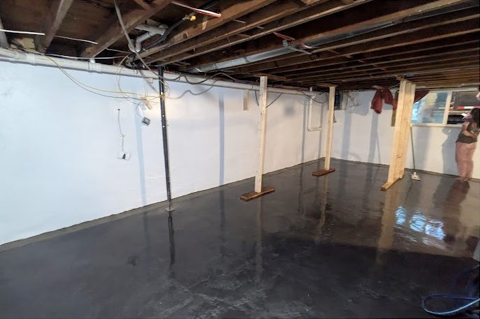 White-lined basement walls, timber posts and a glossy dark floor