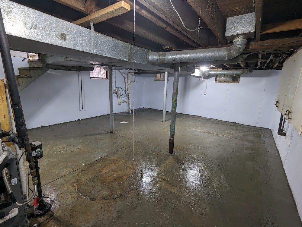 The same basement after the work: white-lined walls and a sealed floor