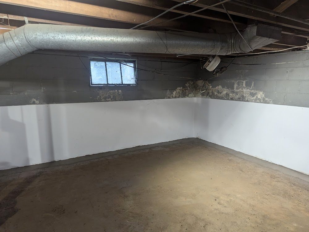 A basement corner with white lower-wall liner