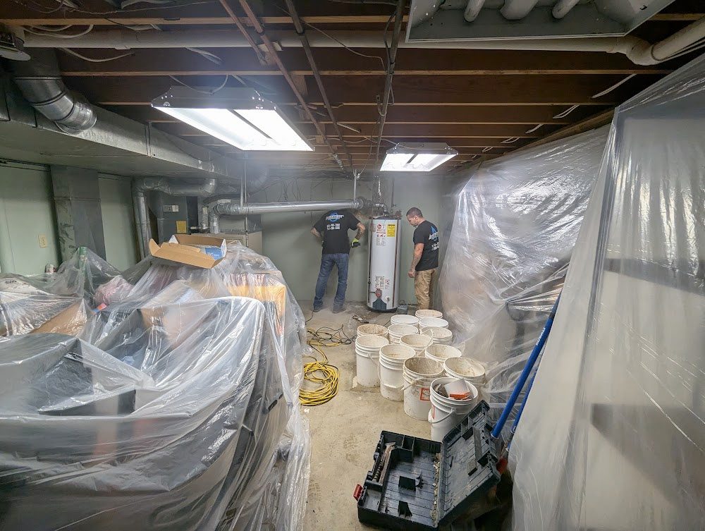 Plastic sheeting over the contents of a basement while the Watertight crew works.