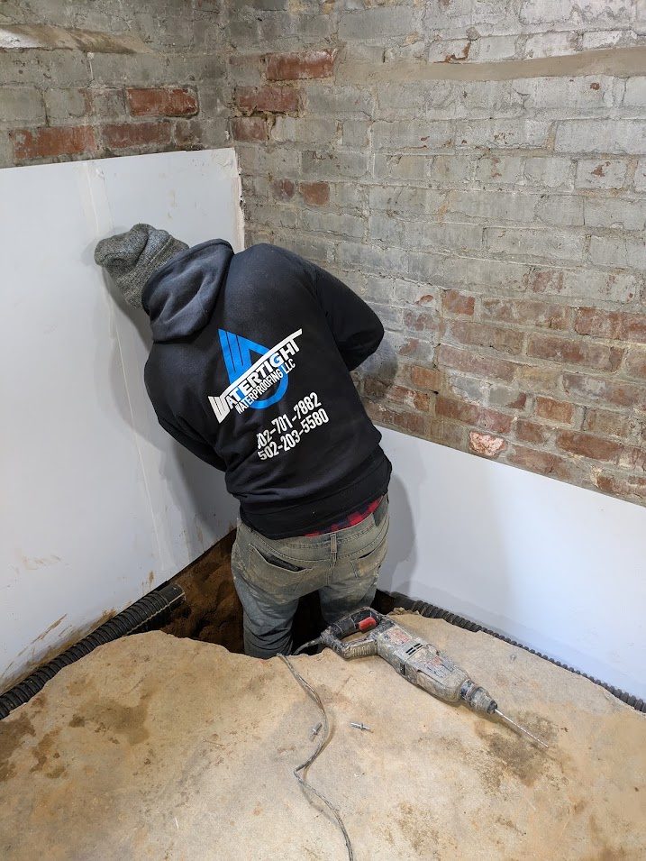 Worker fitting white liner to old masonry wall