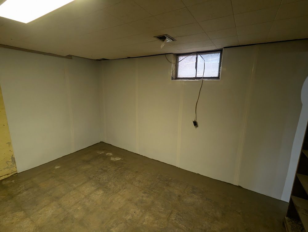 Basement corner with smooth white wall lining