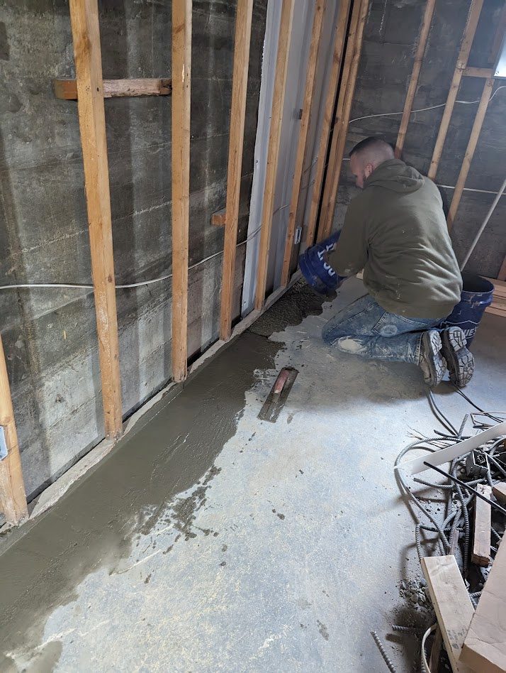 Worker at perimeter below exposed wall studs