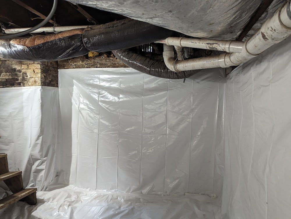 Liner fitted over a masonry basement corner below ducts