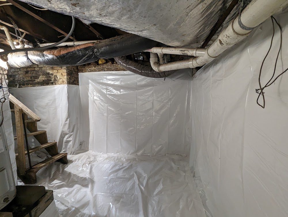 Lined masonry basement corner with pipes and stairs