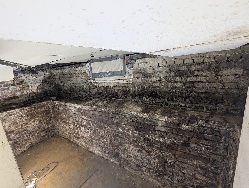 Masonry basement corner with dark wall markings