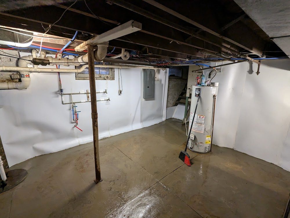 A lined basement with the utilities and a post