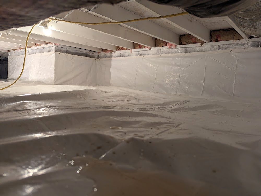 Wide crawl space with continuous white floor and wall liner