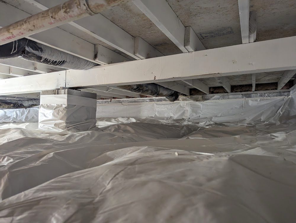 Clean wide crawl space with white liner and wrapped pier