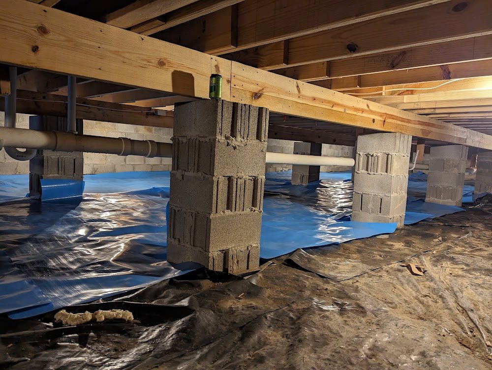 Crawl space piers and blue sheet material on floor