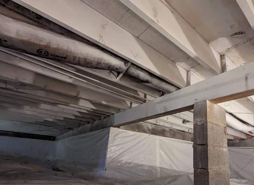 Lined crawl space with white-coated joists and a pier