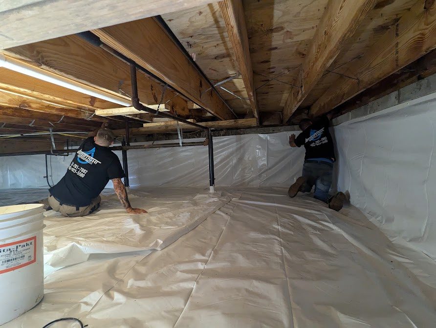 Workers fitting white liner along a crawl space wall