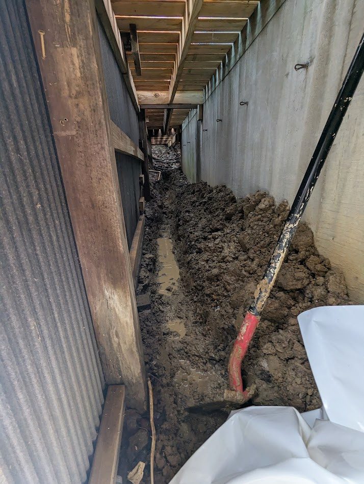 A trench dug along the block wall of a crawl space on a Watertight job.