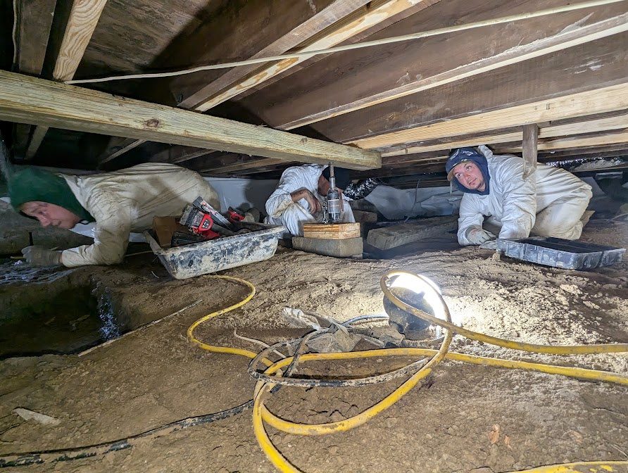 Two workers under low joists with protective coveralls