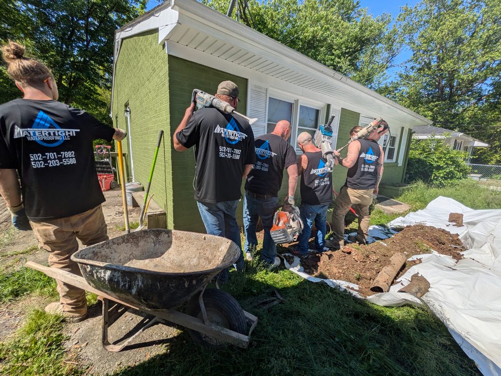 The Watertight crew around a jobsite wheelbarrow outside a Louisville home
