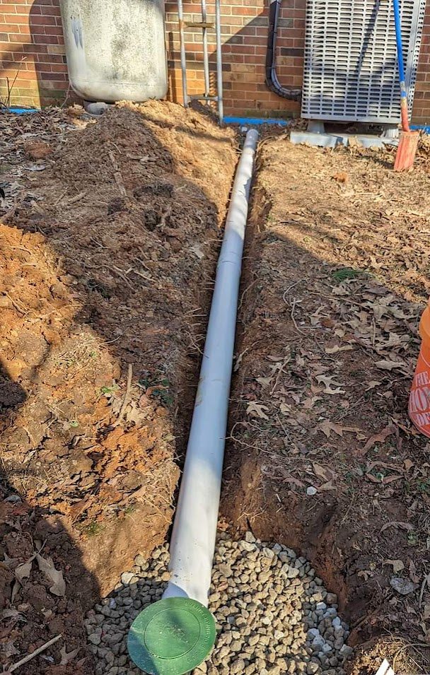 Pipe in gravel trench ending at green cover