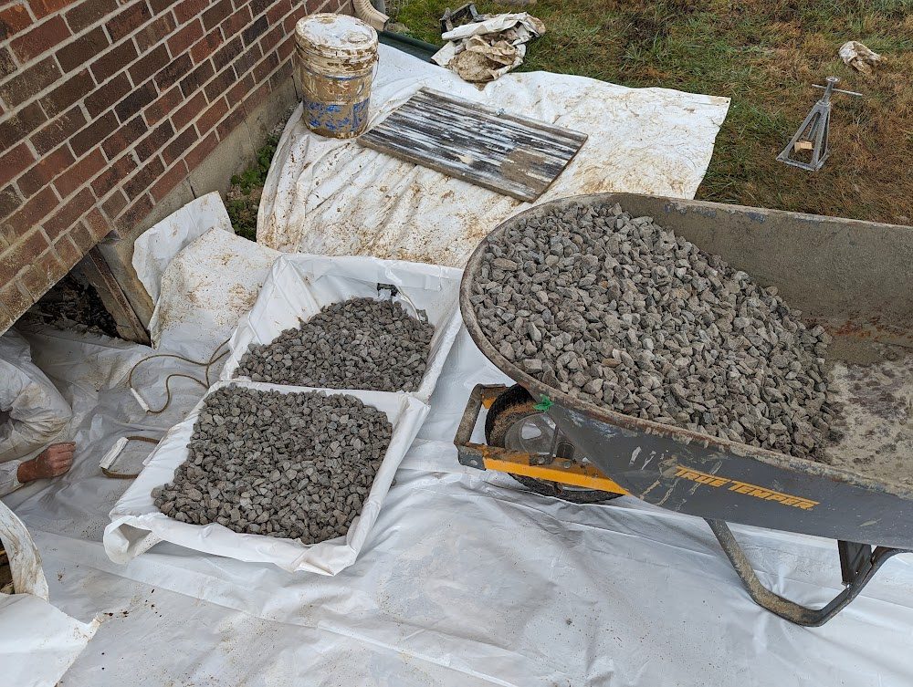 Wheelbarrow of gravel beside covered ground