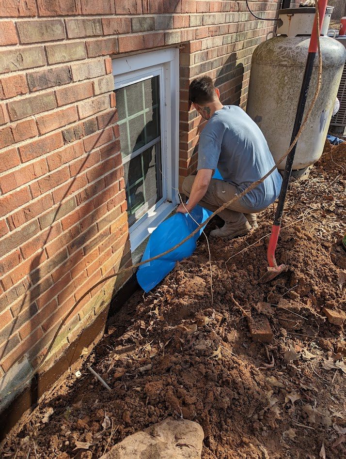 Worker applying blue material beneath window