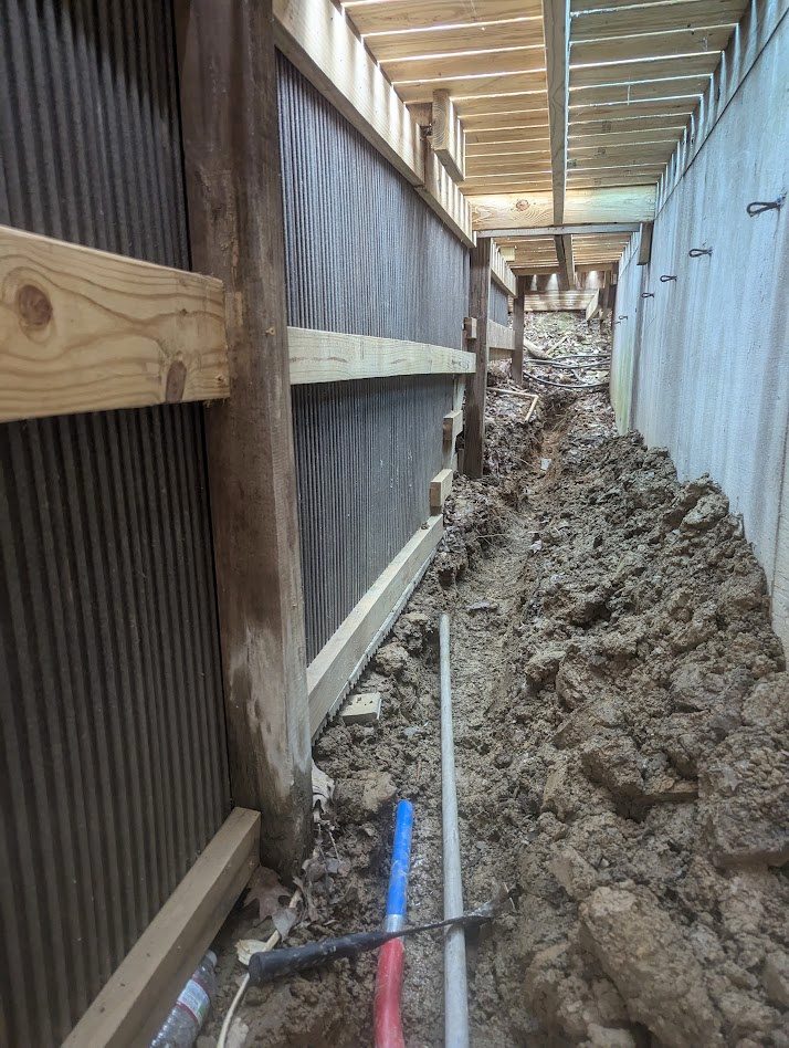 Narrow trench beside foundation under deck