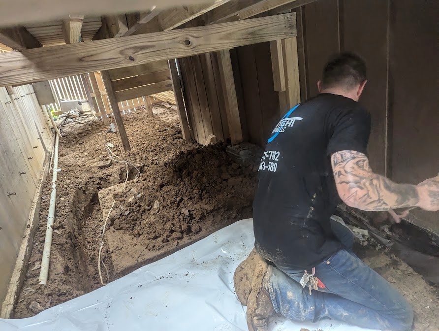 Worker kneeling beneath raised deck