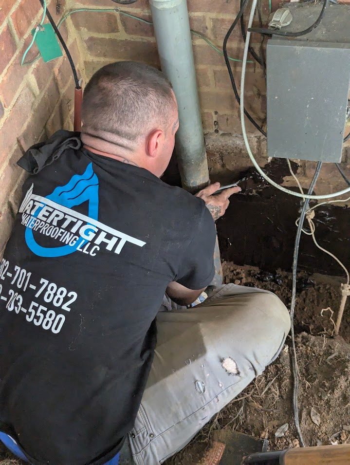A worker by the utility meters on a brick wall