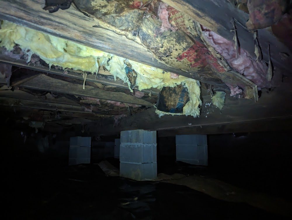 Damaged joist and hanging insulation in a crawl space