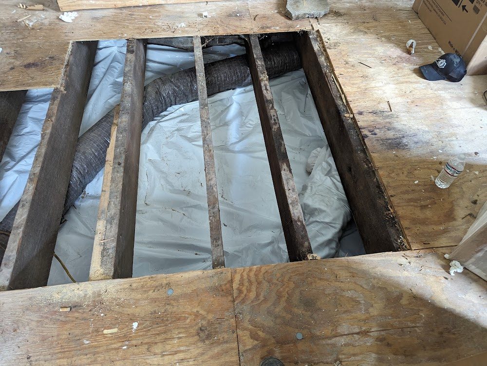 Open subfloor with visible joists and liner beneath