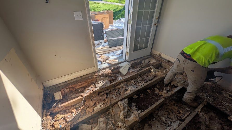 Worker removing material at open floor edge