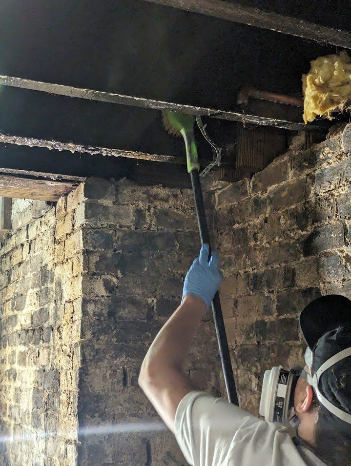 Gloved worker reaching overhead