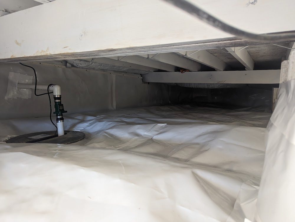 Wide crawl space with white liner and sump at left