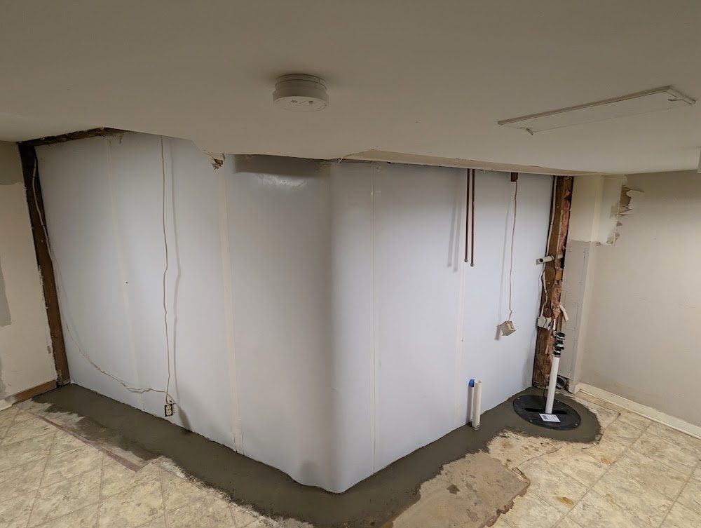 White wall liner and sump in basement corner