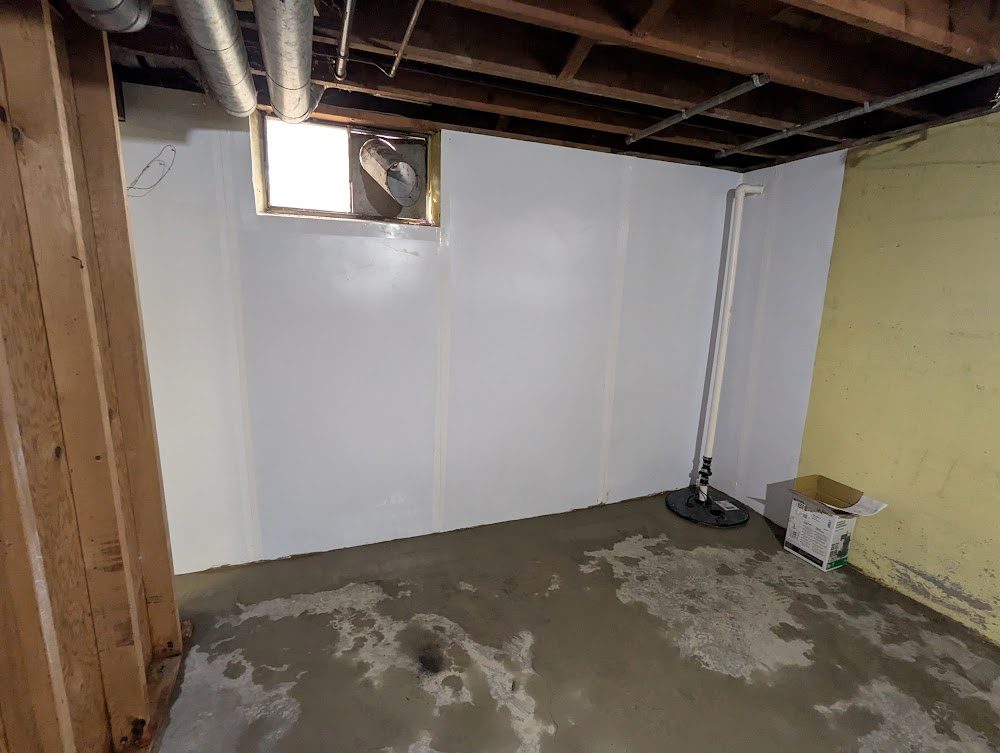 Basement wall liner and sump under exposed joists