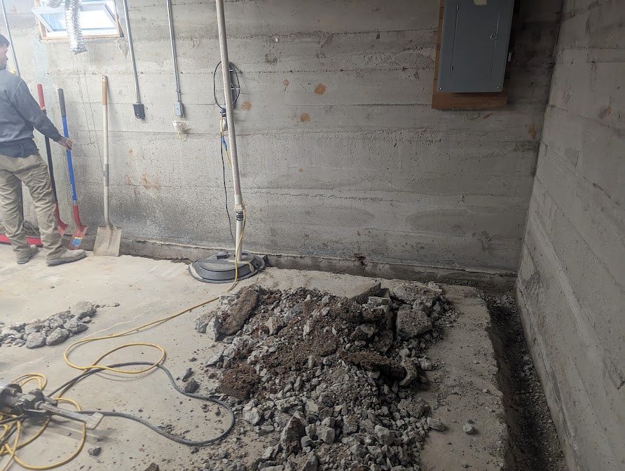 Excavated basement floor and discharge pipe